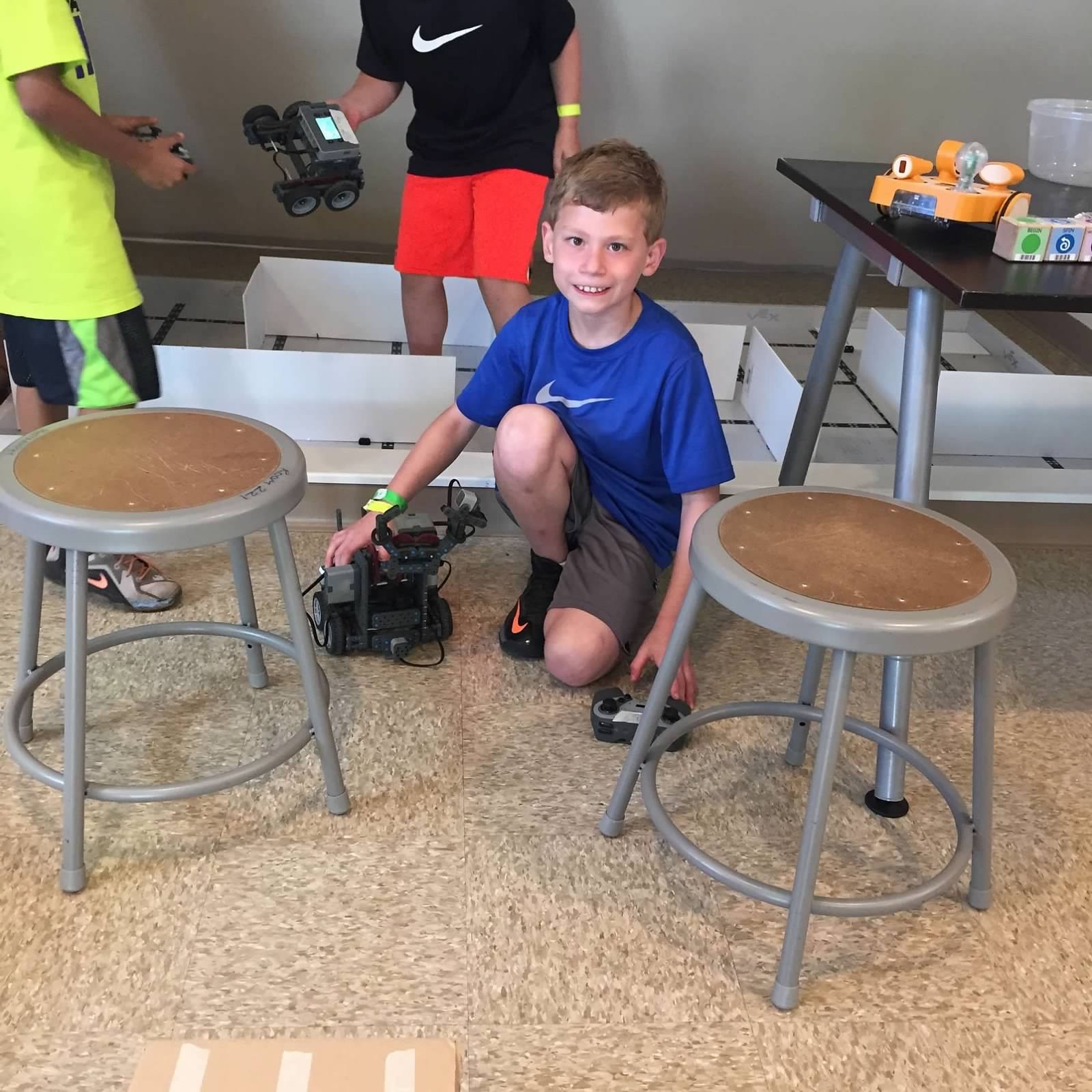 Samuel as a child with a robot at robotics camp